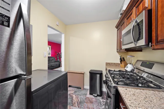 a kitchen with stainless steel appliances granite countertop a stove a sink and a microwave