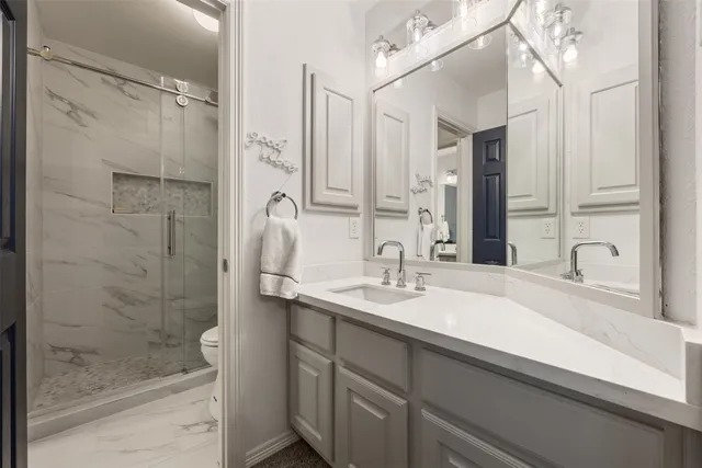 a bathroom with a shower sink and mirror