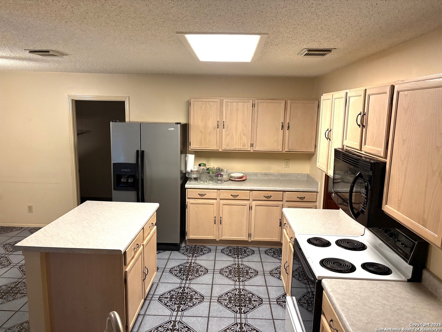 7501 Avery Road Live Oak, TX 78233 - Photo 25 of 32 a kitchen with a sink a refrigerator a stove and white cabinets