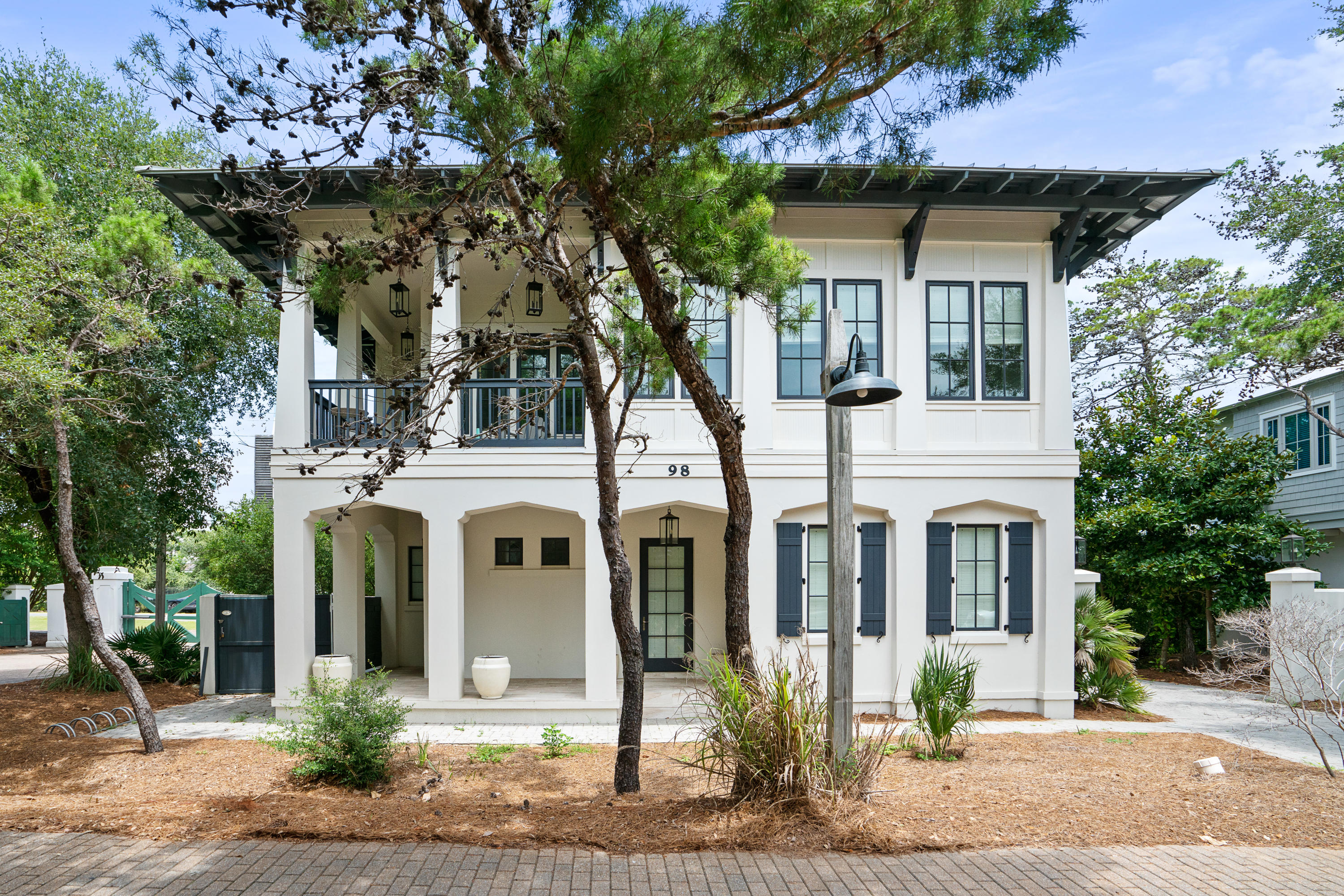 a front view of a house with a tree