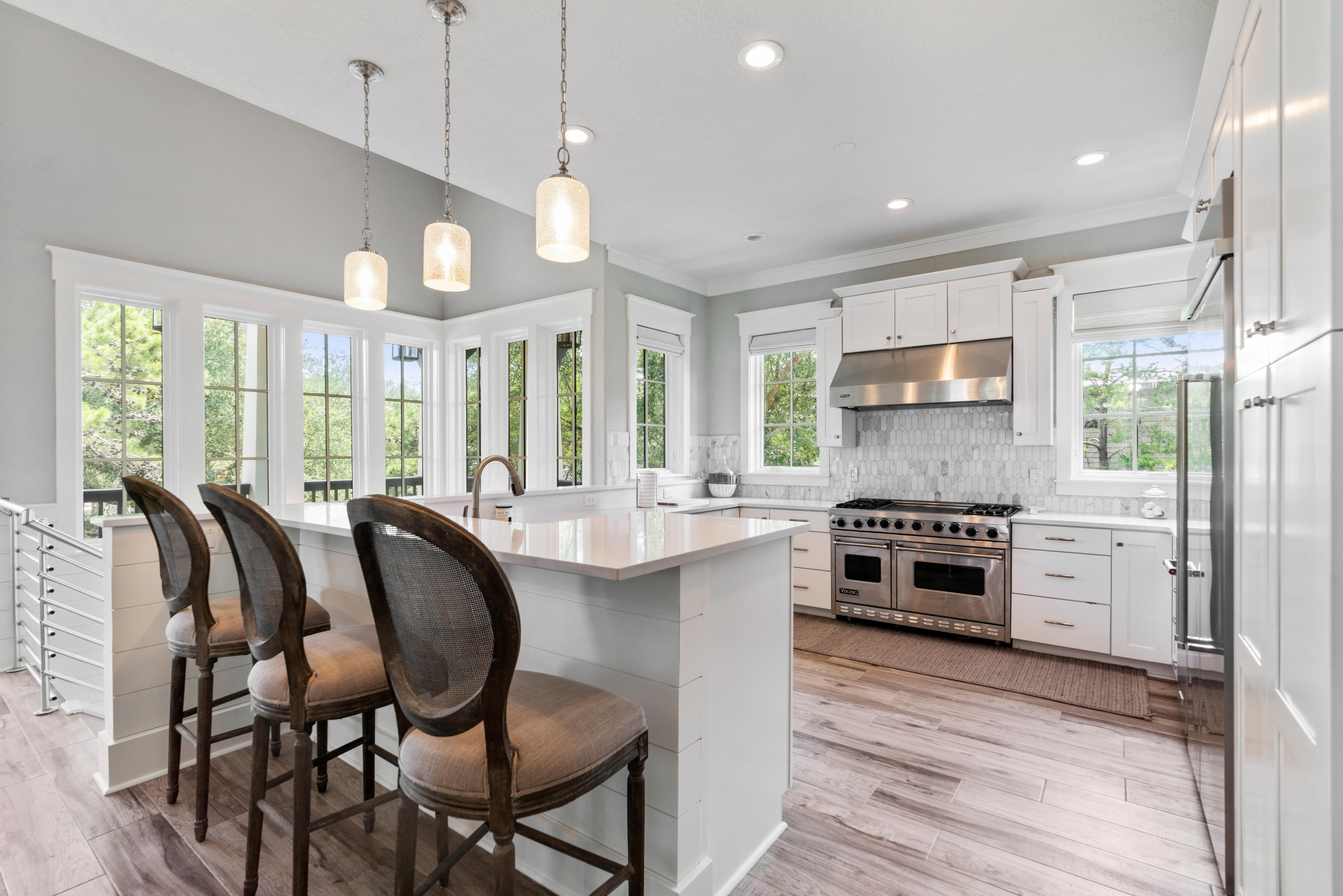 98 Pine Crest Circle Inlet Beach, FL 32461 - Photo 31 of 66 a kitchen with stainless steel appliances granite countertop a stove top oven a refrigerator a sink and chairs with wooden floor
