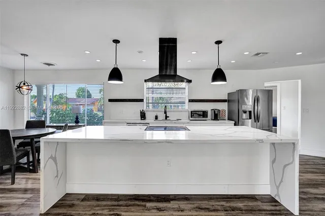 a large kitchen with stainless steel appliances granite countertop a sink and a stove