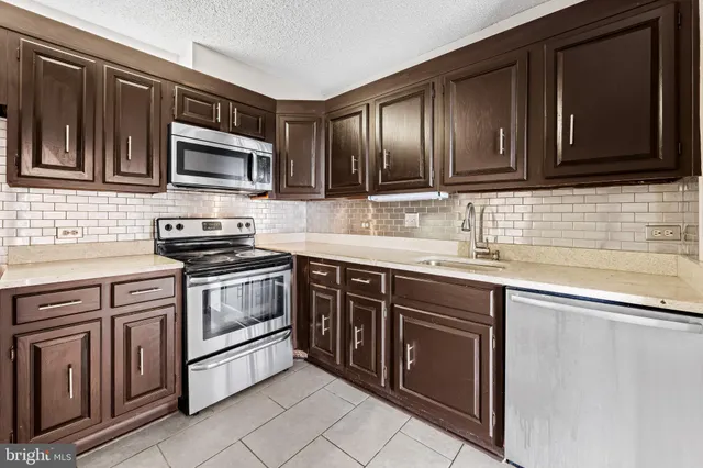 a kitchen with stainless steel appliances granite countertop a sink stove and microwave