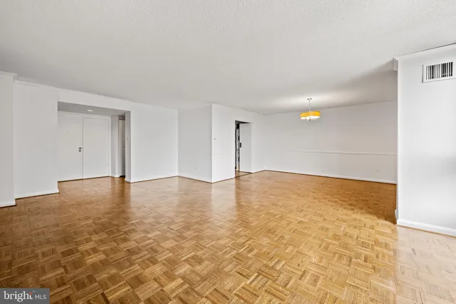 a view of empty room with wooden floor
