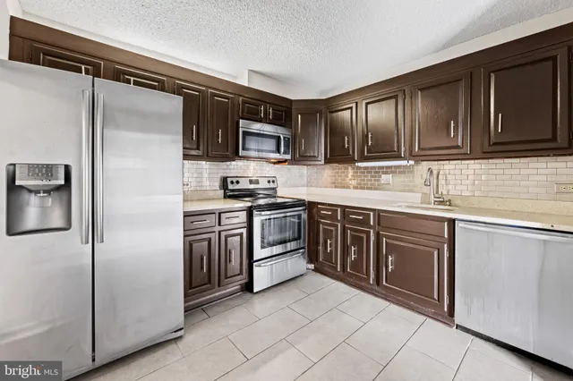 a kitchen with stainless steel appliances granite countertop a refrigerator stove and sink