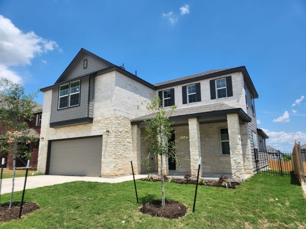 a front view of a house with a yard and trees