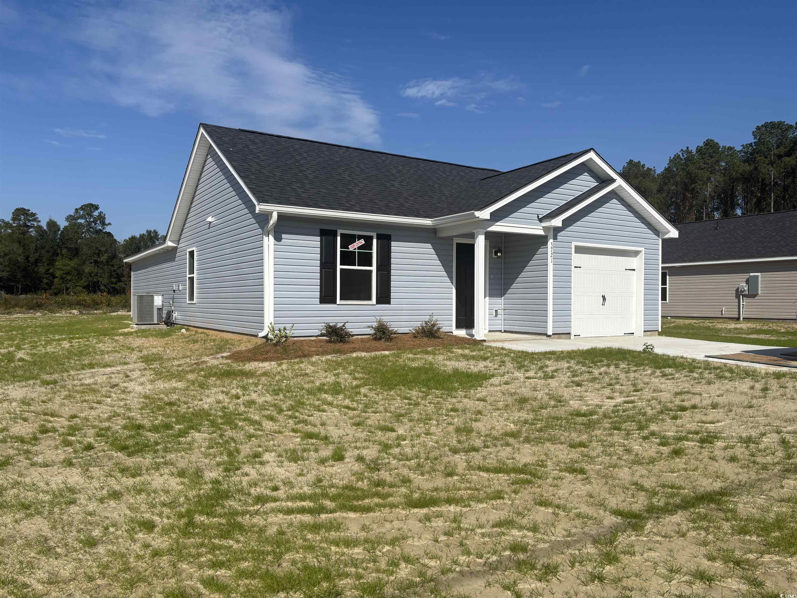 Single story home with a front lawn, a shingled roof, a garage, and driveway