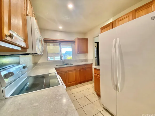 a kitchen with stainless steel appliances granite countertop a refrigerator and a sink