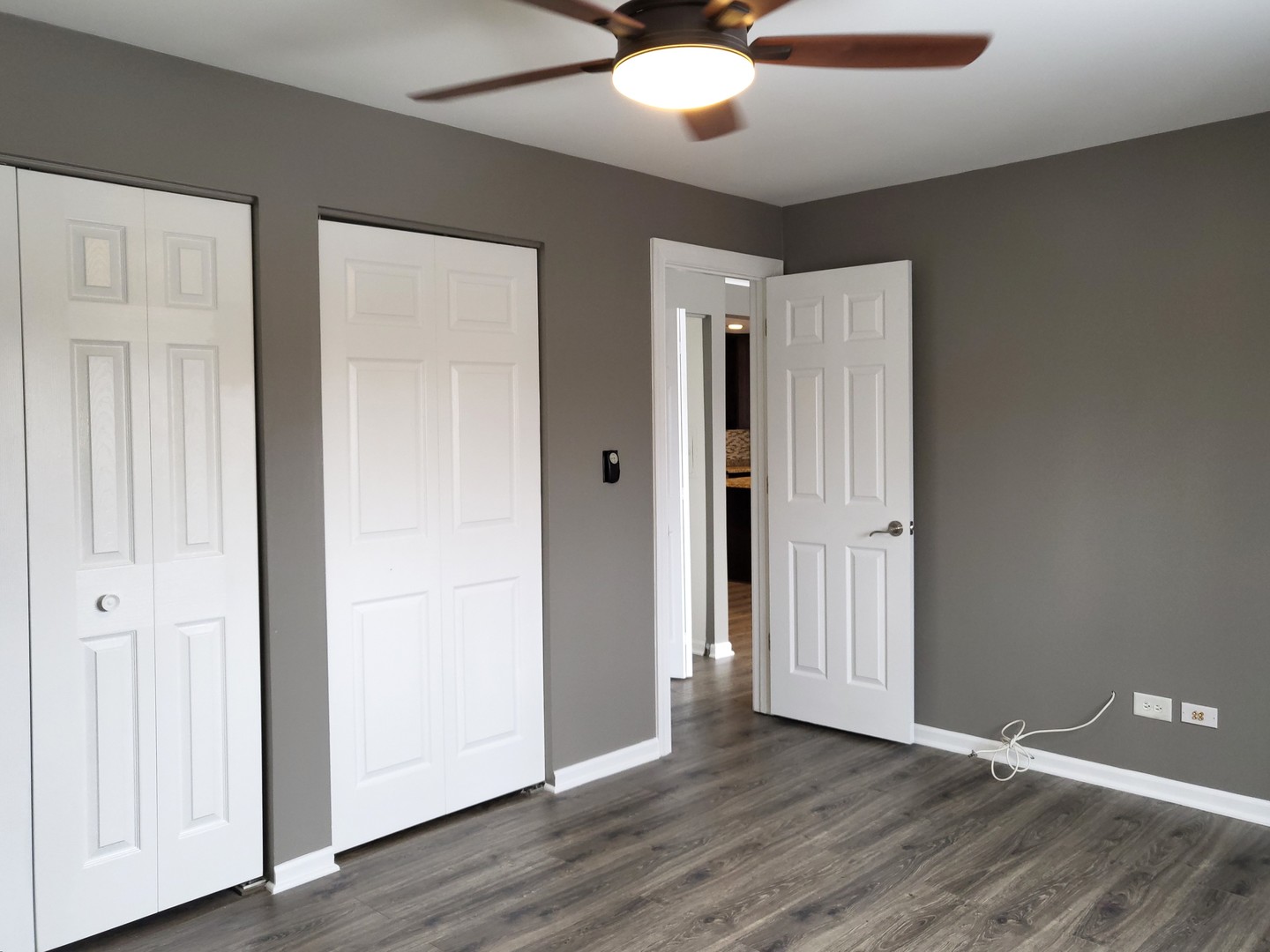 4809 West Engle Road, Unit 3A Alsip, IL 60803 - Photo 7 of 11 an empty room with wooden floor and a ceiling fan
