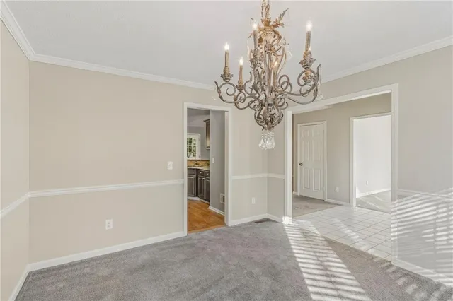 a view of an empty room with chandelier fan and fire place