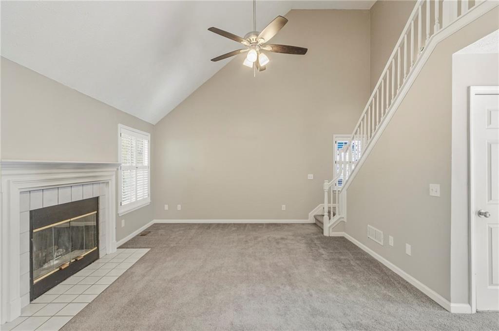 715 Welford Road Northwest Suwanee, GA 30024 - Photo 14 of 50 a view of an empty room with chandelier fan and fire place