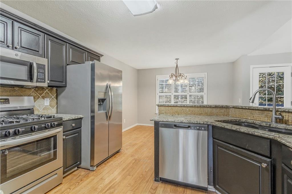 715 Welford Road Northwest Suwanee, GA 30024 - Photo 19 of 50 a kitchen with granite countertop stainless steel appliances a stove and a sink