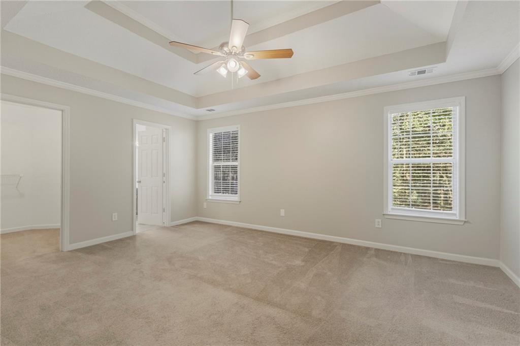 715 Welford Road Northwest Suwanee, GA 30024 - Photo 21 of 50 an empty room with chandelier fan and windows