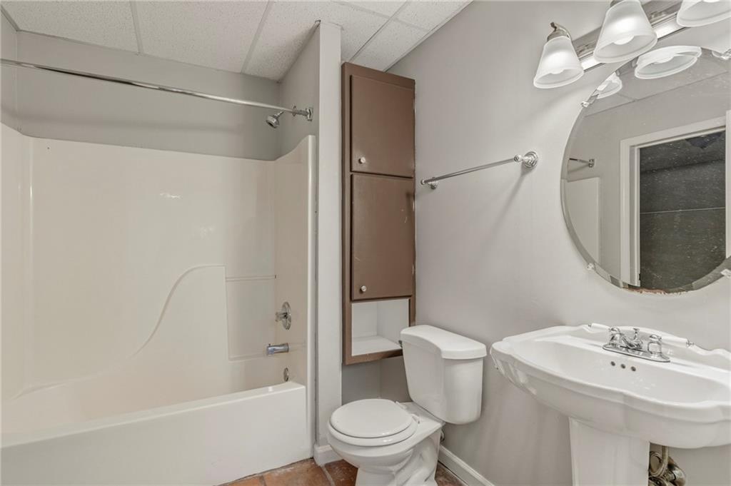 715 Welford Road Northwest Suwanee, GA 30024 - Photo 39 of 50 a bathroom with a sink a toilet a mirror and shower