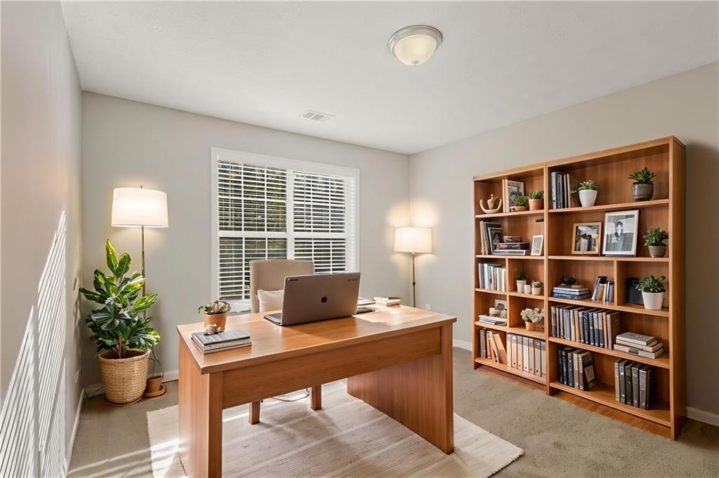 715 Welford Road Northwest Suwanee, GA 30024 - Photo 6 of 50 a workspace with furniture and a bookshelf