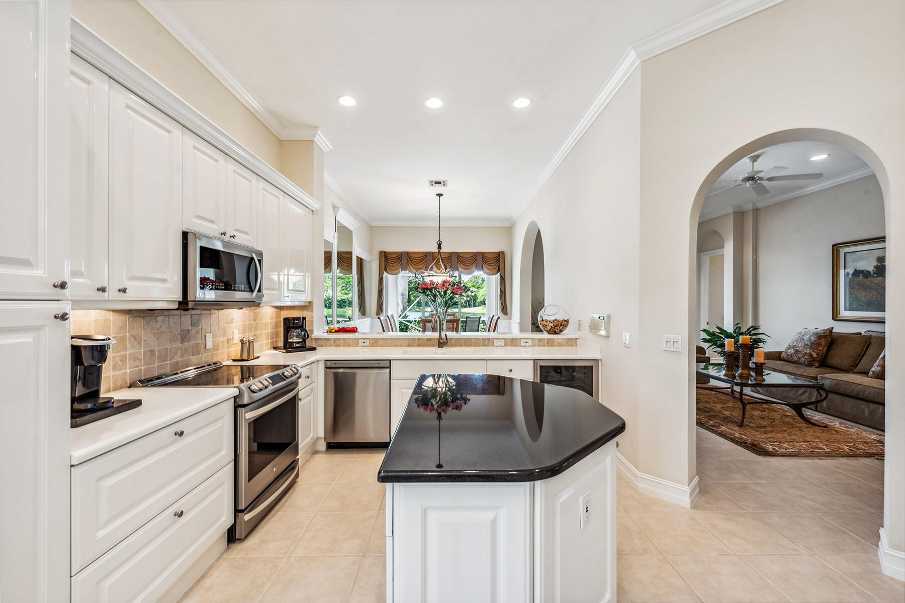8499 Mallards Way Naples, FL 34114 - Photo 6 of 50 a kitchen with kitchen island granite countertop a sink stainless steel appliances and white cabinets