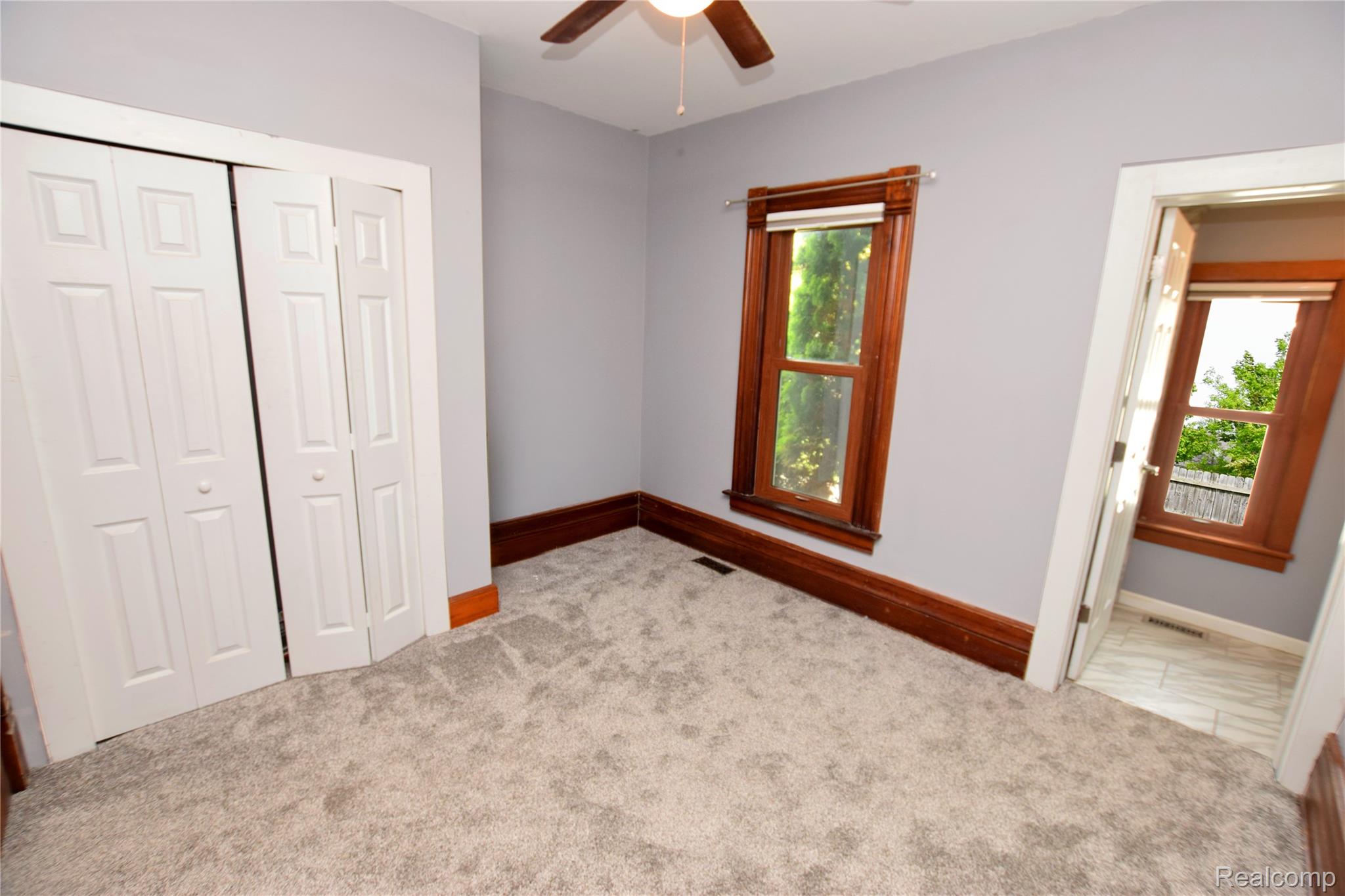 404 North Adelaide Street Fenton, MI 48430 - Photo 8 of 23 Plush carpeting and light gray walls complement the rich wood trim