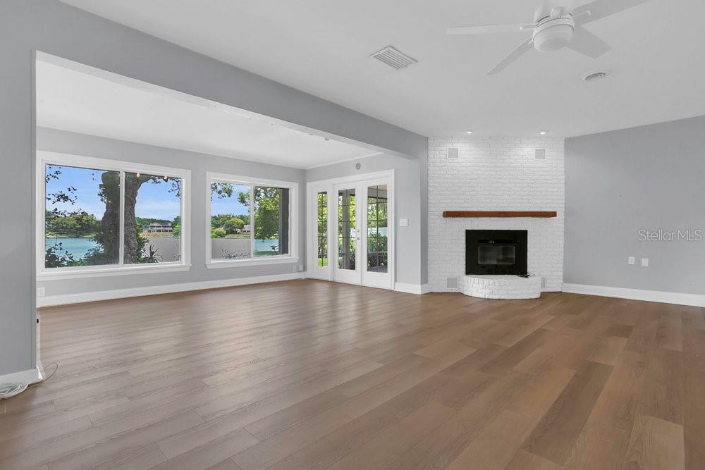 3605 Pershing Avenue Orlando, FL 32812 - Photo 11 of 35 wooden floor fireplace and windows in an empty room