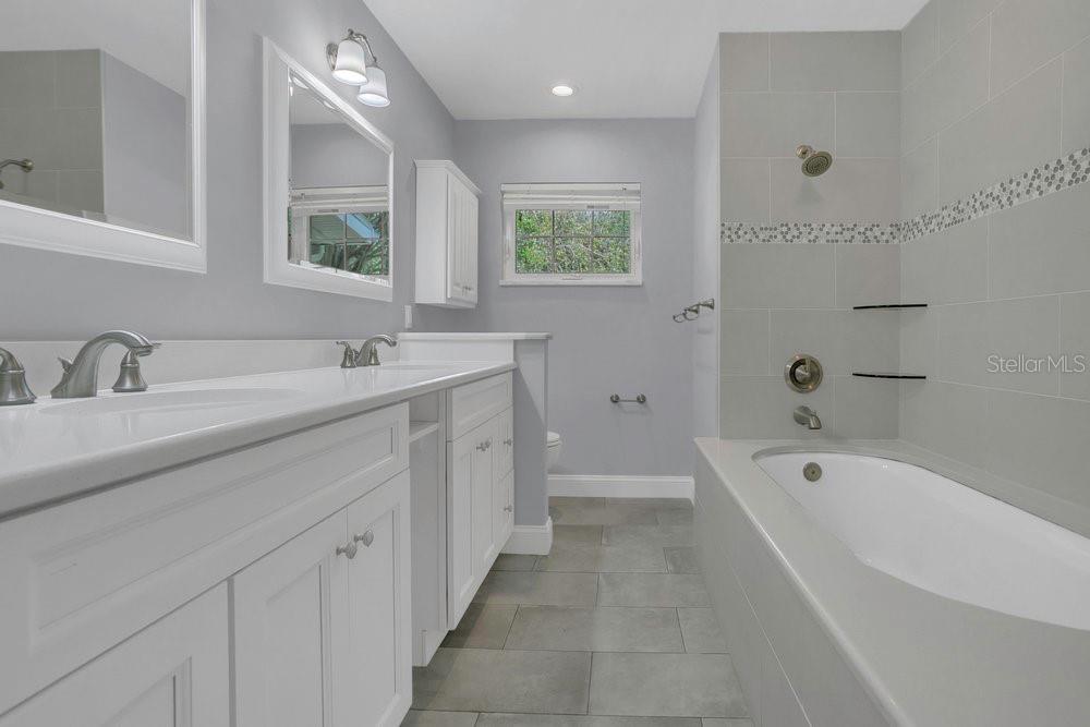 3605 Pershing Avenue Orlando, FL 32812 - Photo 14 of 35 a spacious bathroom with double vanity a mirror a bathtub and a shower