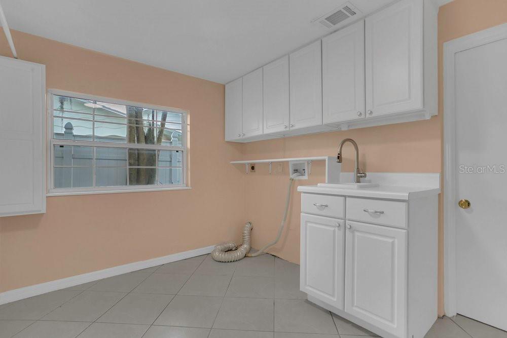 3605 Pershing Avenue Orlando, FL 32812 - Photo 22 of 35 a kitchen with white cabinets and sink