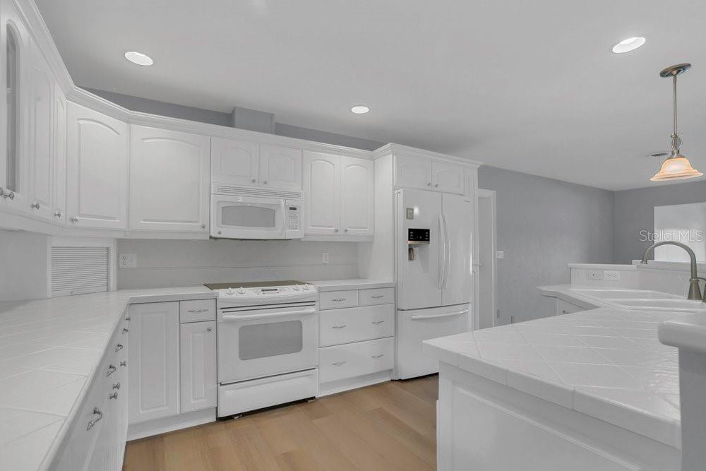 3605 Pershing Avenue Orlando, FL 32812 - Photo 7 of 35 a kitchen with white cabinets and white appliances