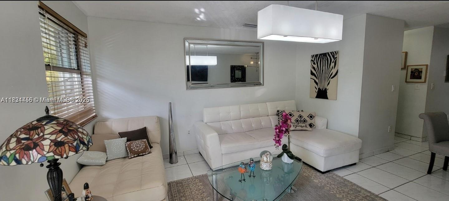 7121 Southwest 129th Avenue, Unit 5 Miami, FL 33183 - Photo 2 of 19 a living room with furniture and a mirror