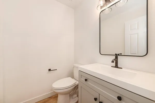 a bathroom with a sink toilet and mirror
