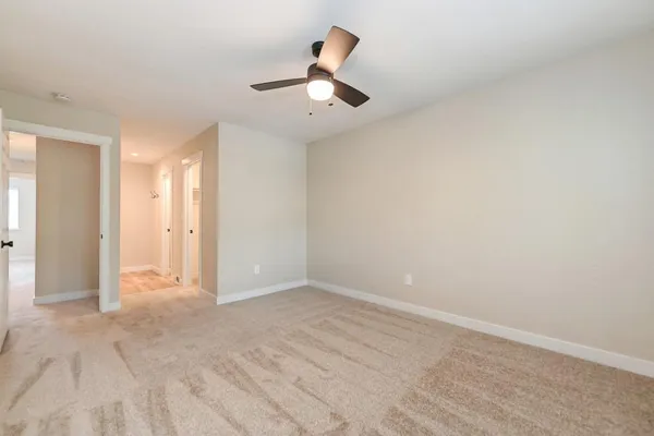 an empty room with fan and entrance