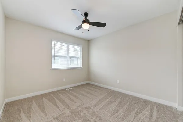 an empty room with windows and ceiling fan view