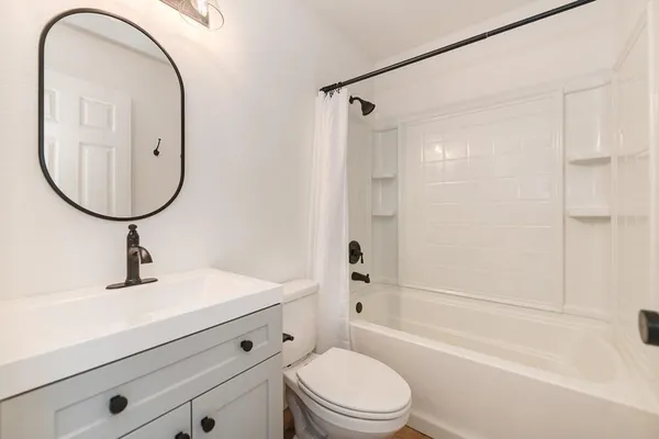 a bathroom with a sink a toilet and a mirror