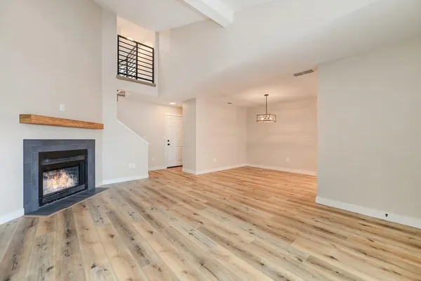 a view of empty room with wooden floor and fireplace