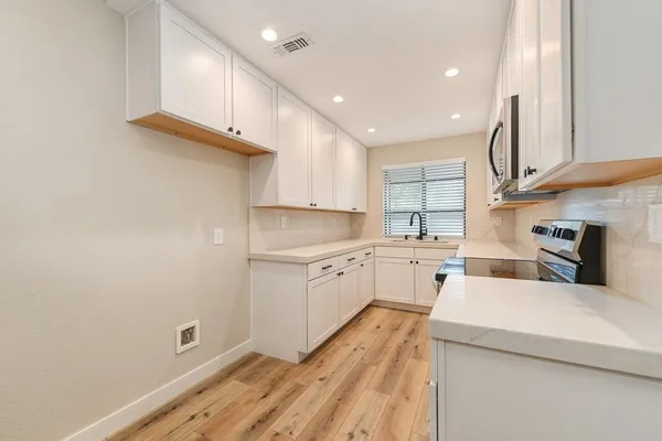 a kitchen with white cabinets and white appliances