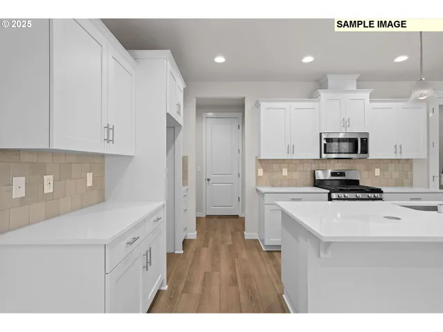 a kitchen with stainless steel appliances a refrigerator sink and white cabinets