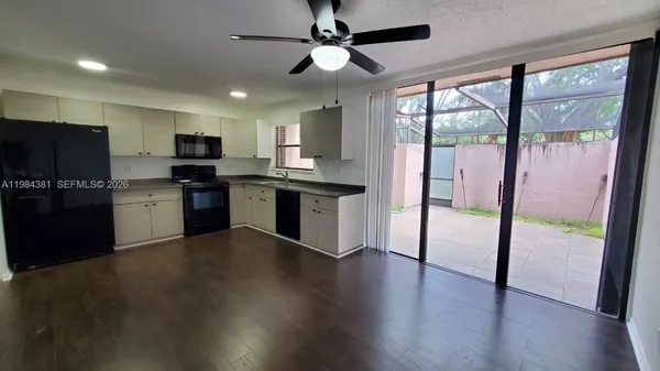 a kitchen with stainless steel appliances granite countertop a stove top oven a sink and a refrigerator