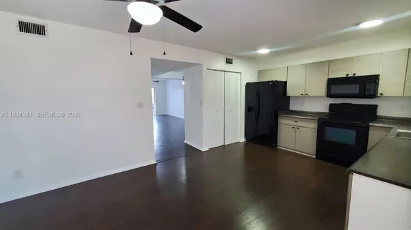 a view of a kitchen with a sink and a refrigerator