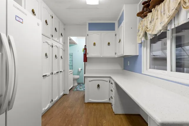 a kitchen with cabinets and a refrigerator