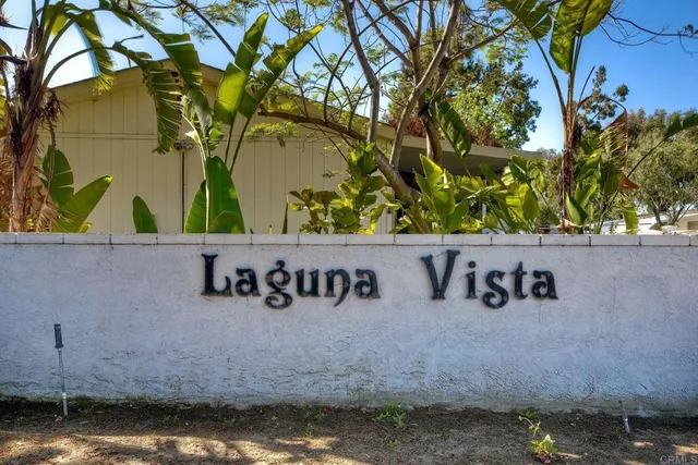 a kitchen with stainless steel appliances granite countertop a sink a stove a refrigerator cabinets and a dining table