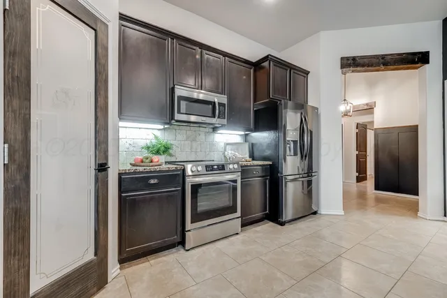 a kitchen with stainless steel appliances granite countertop a refrigerator and a stove