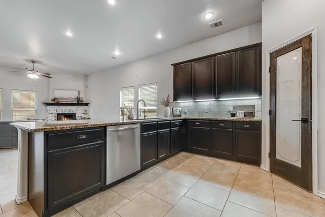 a large kitchen with a large counter top space appliances and cabinets