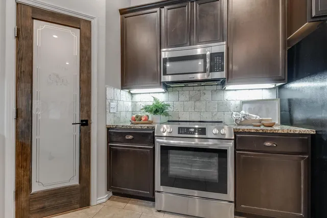 a kitchen with stainless steel appliances granite countertop a stove microwave and refrigerator