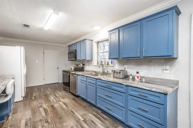a kitchen with granite countertop wooden cabinets stainless steel appliances a sink and a window