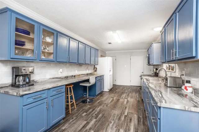 a kitchen with stainless steel appliances granite countertop lots of counter top space and wooden floor