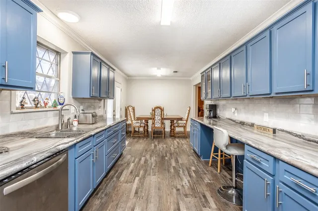 a kitchen with stainless steel appliances granite countertop wooden cabinets a sink dishwasher a stove and a refrigerator with wooden floor