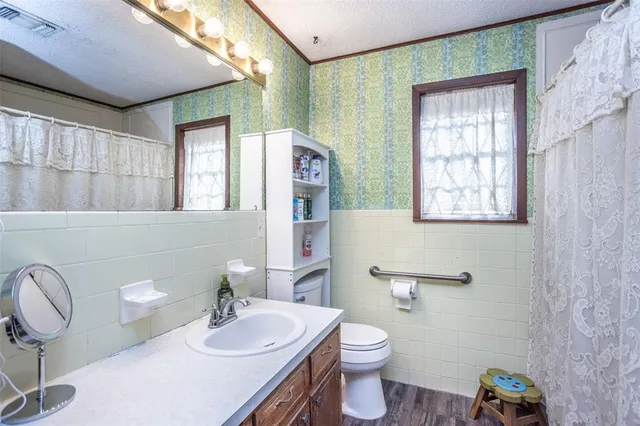 a bathroom with a granite countertop toilet sink and mirror
