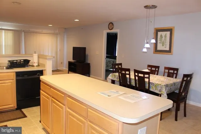 a kitchen with a stove a refrigerator a dining table and chairs