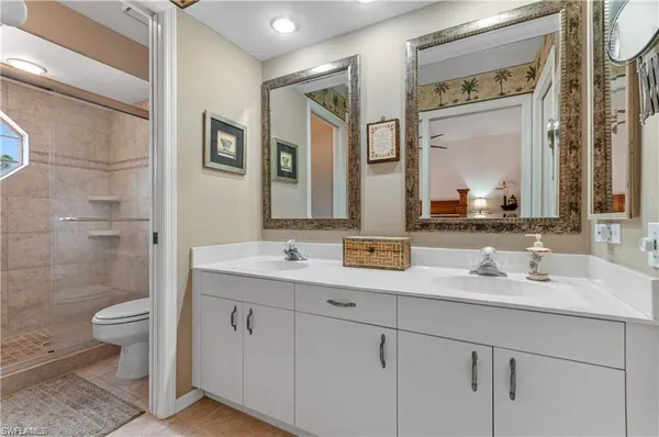 a bathroom with a double vanity sink toilet and shower
