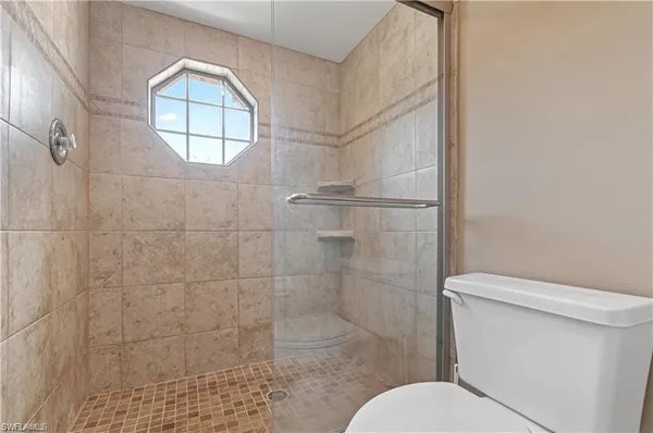 a bathroom with a toilet and a shower