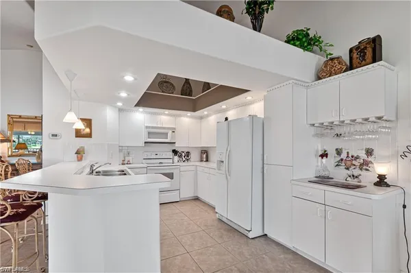 a kitchen with white cabinets and white appliances