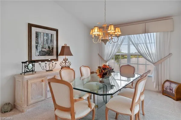 a dining room with furniture a chandelier and window