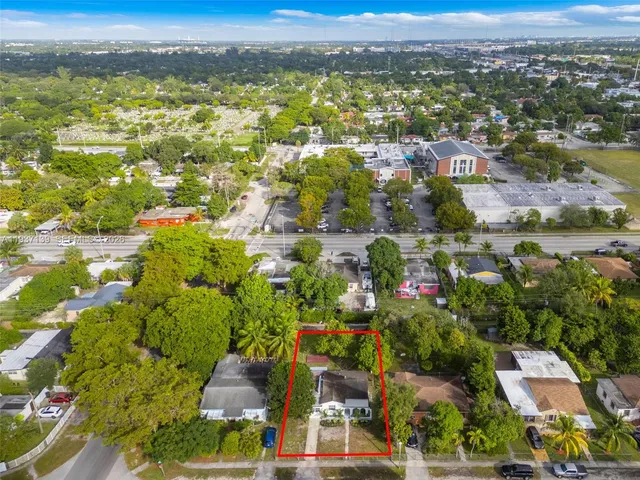 an aerial view of residential houses with outdoor space and trees